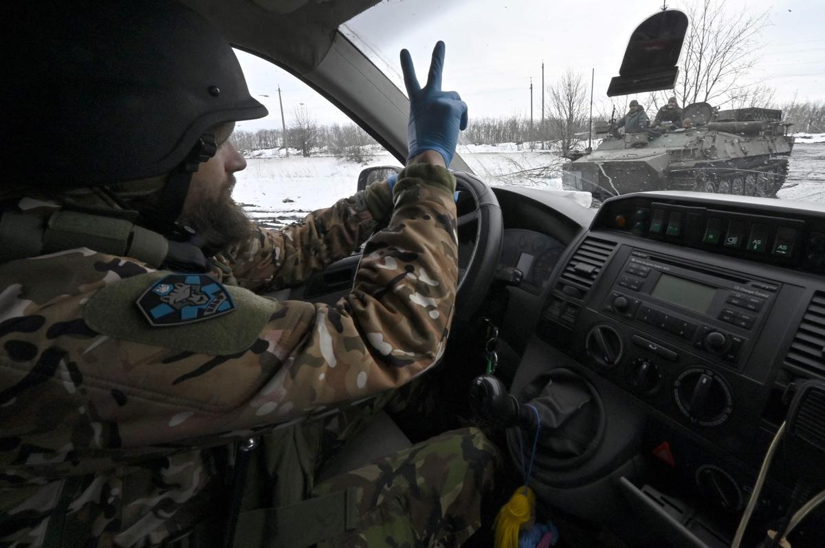 Un conductor de una ambulancia del Batallón de Lobos Da Vinci saluda a sus camaradas mientras conduce por una carretera cerca de la línea del frente cerca de Bakhmut.