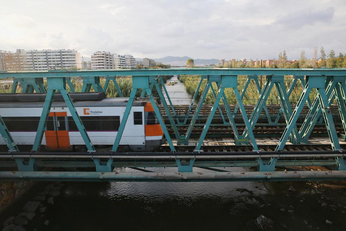 Un tren de Rodalies circulando por el puente del ferrocarril sobre el río Besòs, en Sant Adrià.