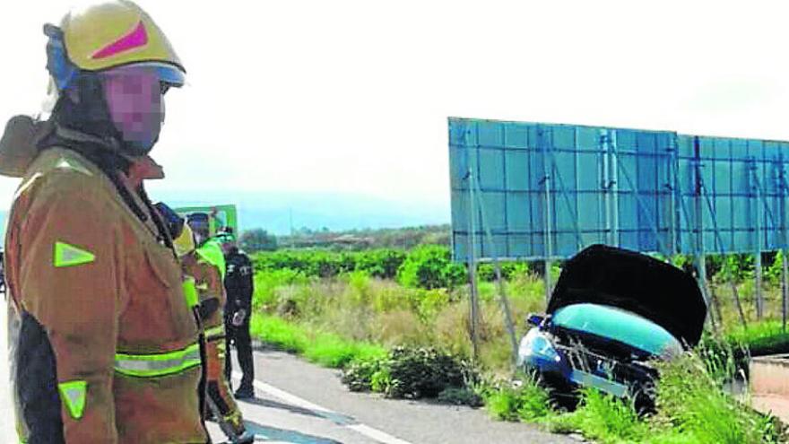 Los bomberos en el lugar del accidente mortal de Dénia, con uno de los coches en segundo plano.