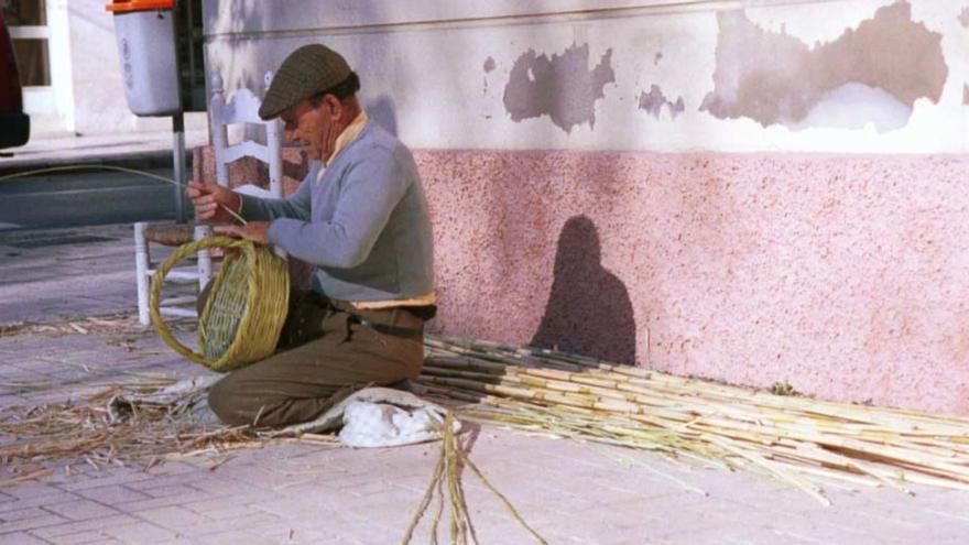 Un artesano realiza una cesta de mimbre en 2000 en una acera de la barriada García Grana.