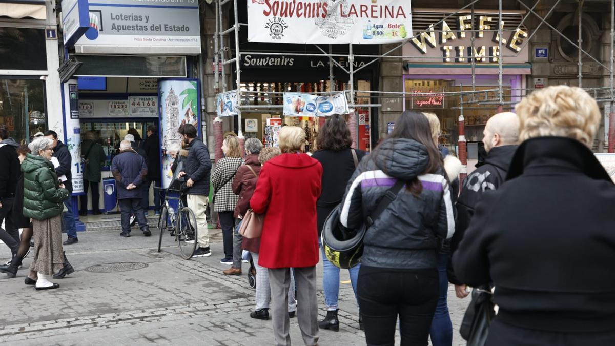 Varias personas hacen cola para comprar décimos de la Lotería del Niño en València