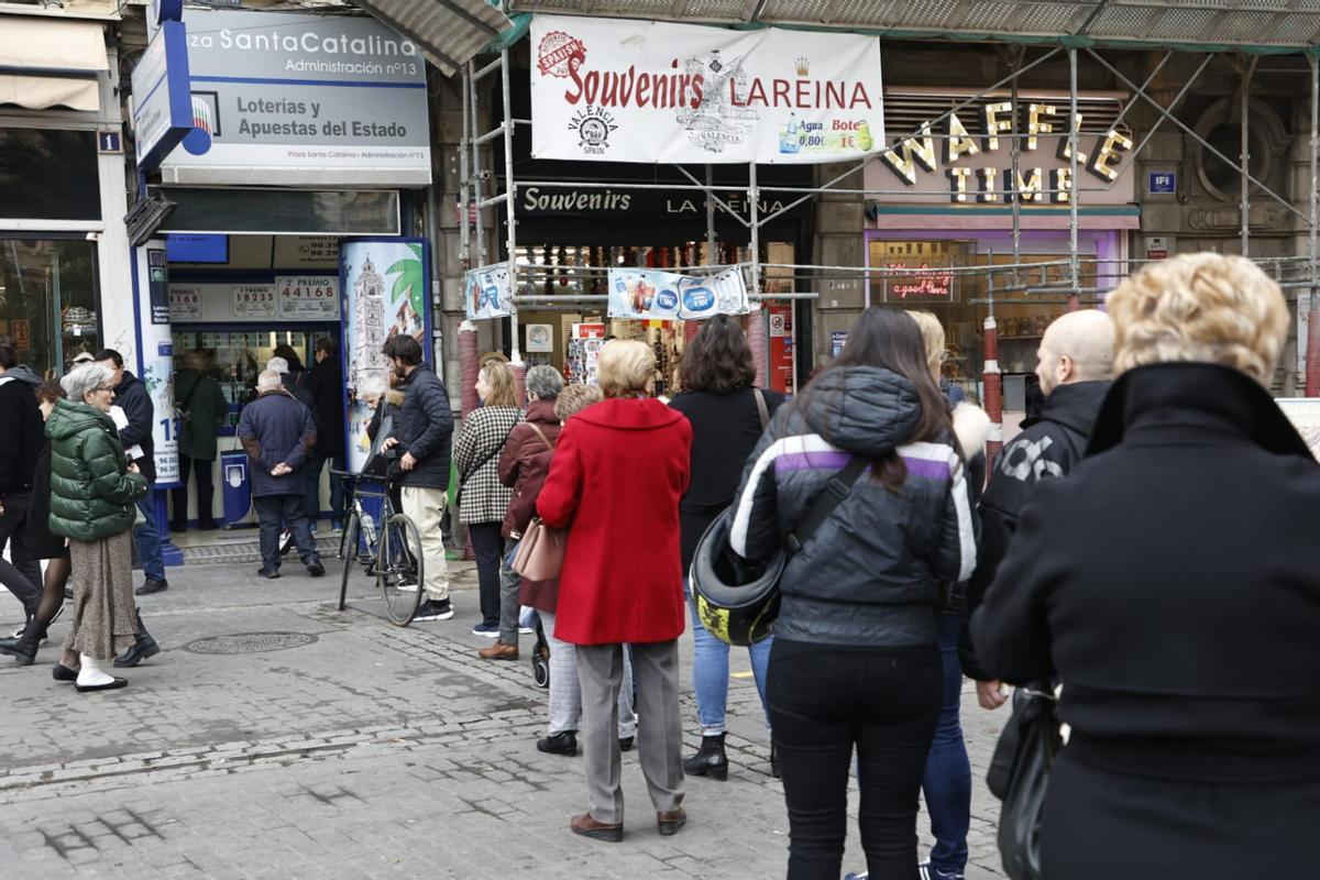 Varias personas hacen cola para comprar décimos de la Lotería del Niño en València