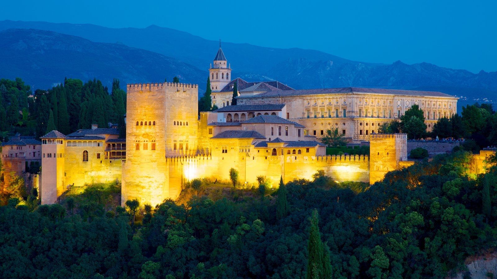 Vista nocturna de la Alhambra de Granada iluminada.