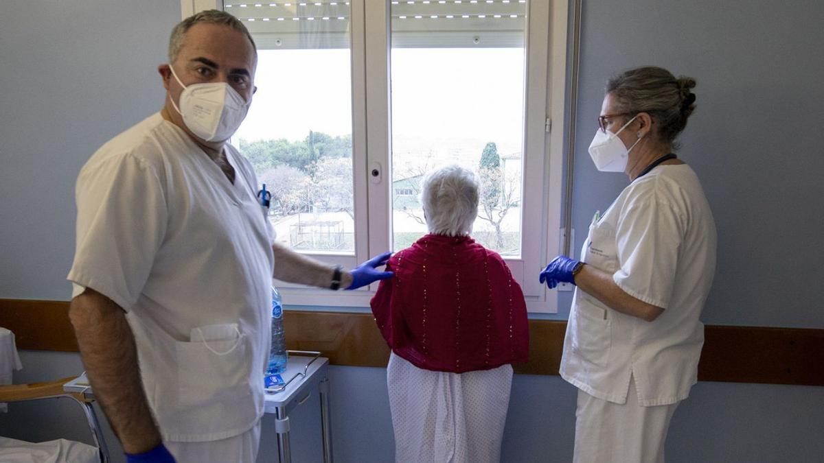 Personal sanitari amb una pacient, en una habitació de l’Hospital de Figueres, aquesta darrera setmana