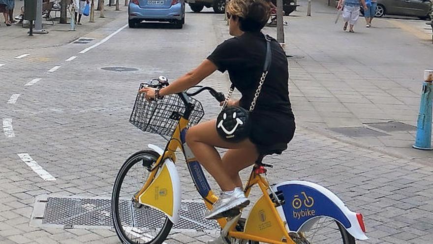 Una usuaria del servicio público de bicicletas por la calle.