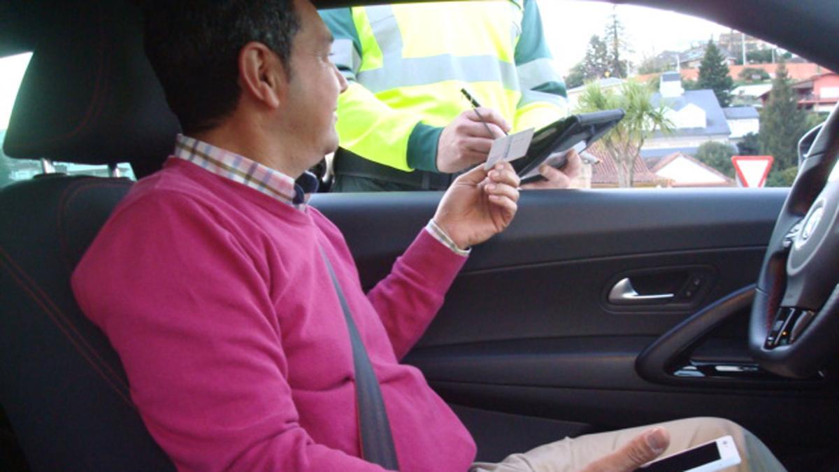 Un agente de la Guardia Civil pone una multa a un conductor