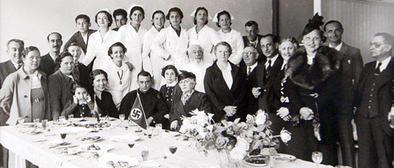 Enfermeras voluntarias del Auxilio Social de Falange Española en Vigo (1938). En la mesa, una bandera de la Alemania nazi. // Archivo Pacheco