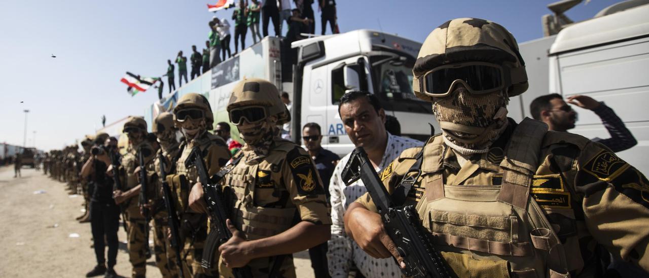 Soldados egipcios custodian los camiones con ayuda humanitaria que esperan en el paso de Rafah para cruzar a Gaza.