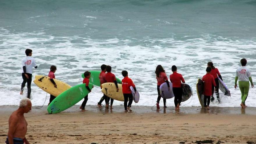 Algunos niños, durante una clase de surf impartida en la playa grovense de A Lanzada.