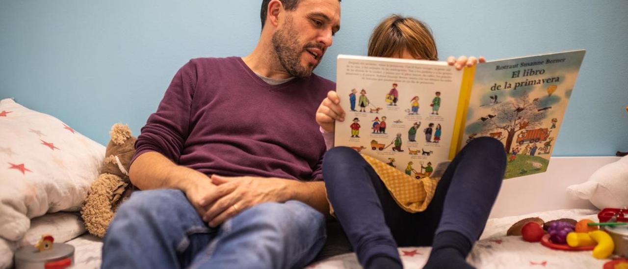 Ignasi Flores junto a su hija adoptada Naiara, leyendo un cuento.