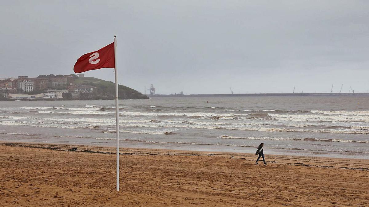 Una bandera roja ondeando ayer a la altura de la escalera 12 de la playa de San Lorenzo. | Juan Plaza