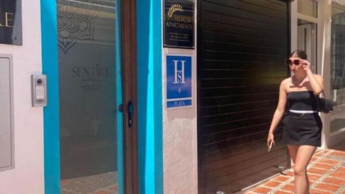 Una joven pasa por delante del acceso a un inmueble de viviendas turísticas en el casco antiguo de Marbella. | L.O.