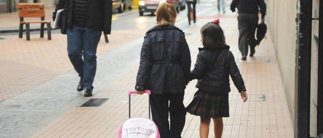 Dos niñas acuden solas caminando al colegio por una calle de Pontevedra.   | // GUSTAVO SANTOS