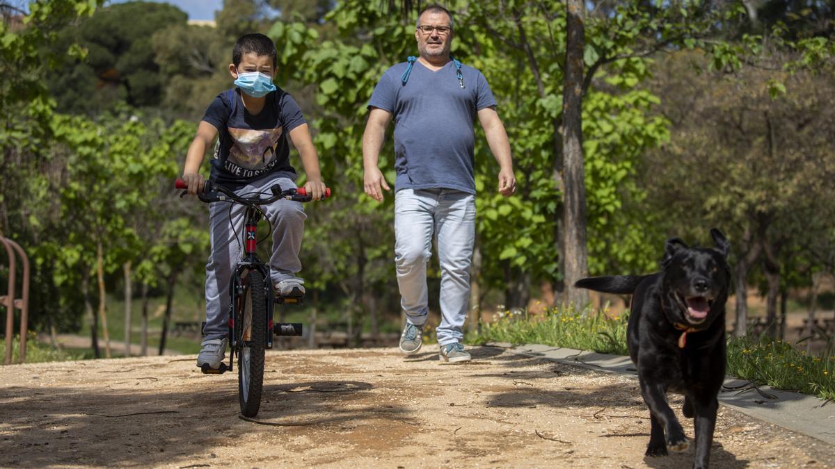 Archivo - Un niño protegido con mascarilla monta en bici junto su padre y su perro, el primer día en el que los menores de 14 años pueden salir a la calle, en Huelva (Andalucía ,España) a 26 de abril de 2020.