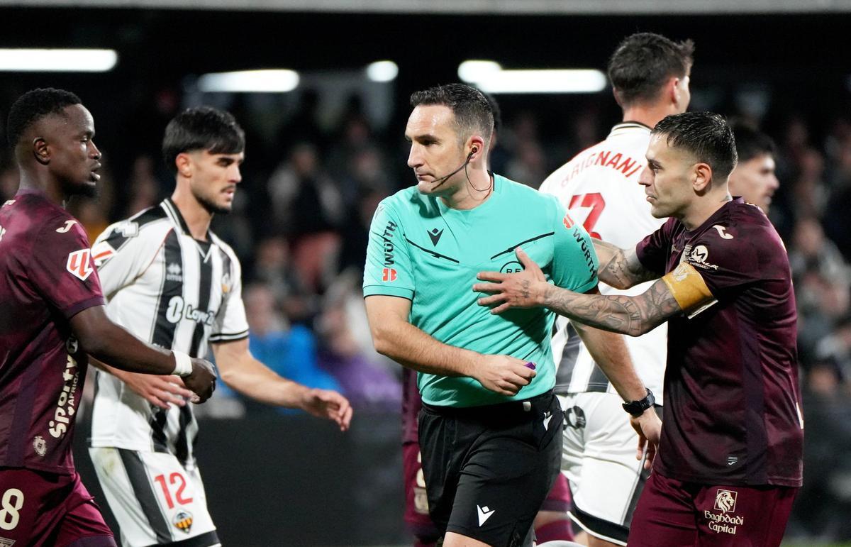 El árbitro manchego Dámaso Arcediano Monescillo, sujetado por Rubén Peña en el Castellón-Leganés (2-0).