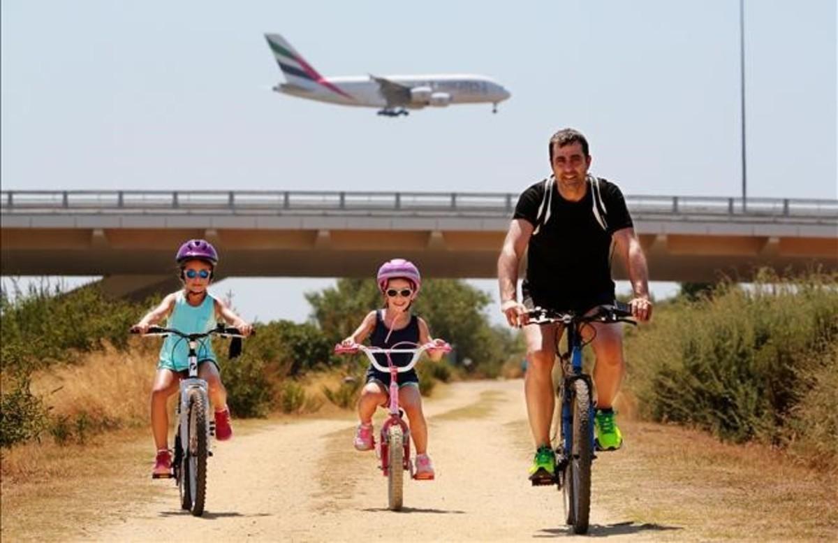 Una familia disfruta de la riqueza natural que envuelve la ruta ciclista por el delta del Llobregat.