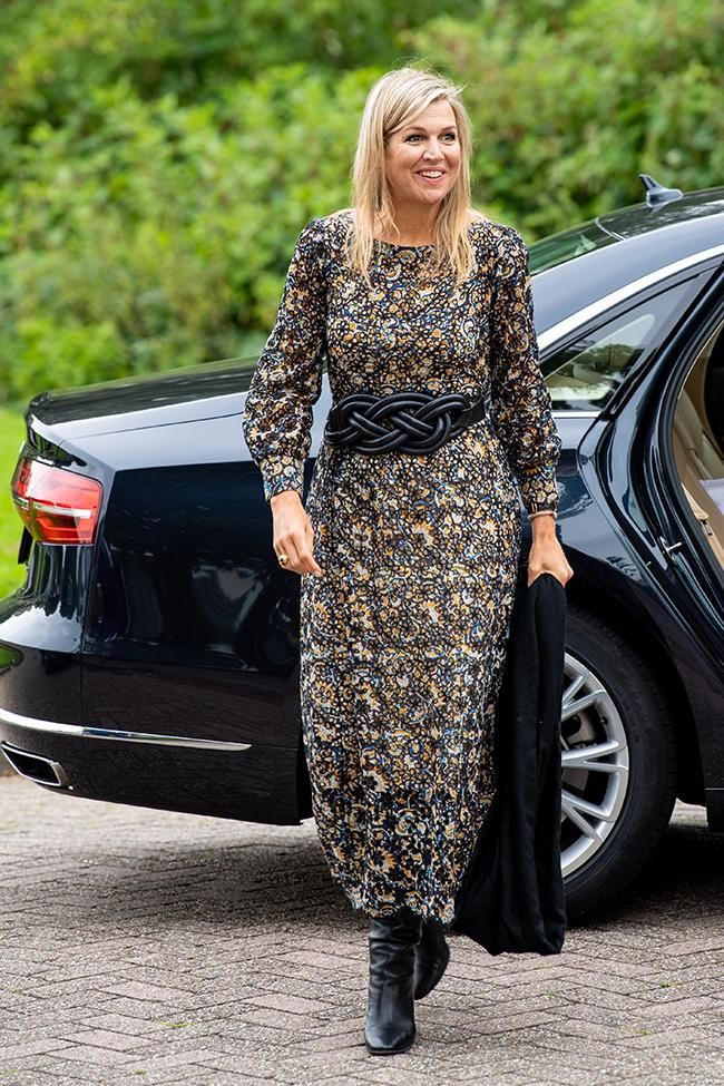 La reina Maxima de Holanda con vestido largo y botas de cuero negro y cinturón a juego