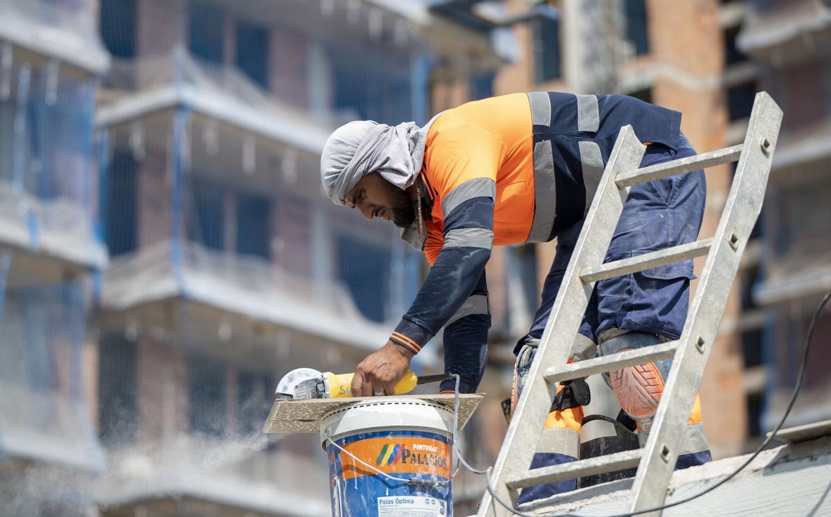 Un operario trabaja en el exterior en la construcción de vivienda nueva en Esplugues de Llobregat.