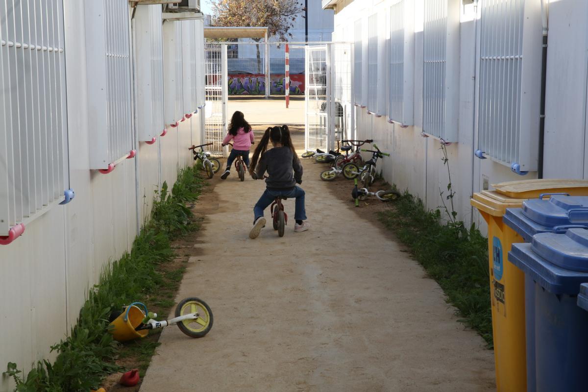 Dos niñas juegan entre los barracones del colegio Paco Candel de L’Hospitalet.