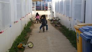 Dos niñas juegan entre los barracones del colegio Paco Candel de L’Hospitalet.