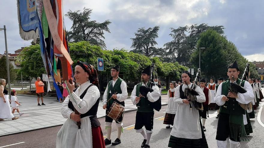 La Pola, al compás internacional: grupos de Chile, Mallorca y Málaga llenan de color las calles de la villa en el desfile del festival folclórico del Carmín