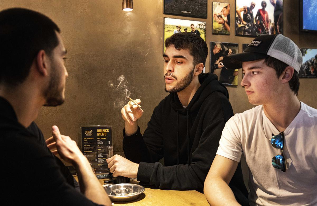 Tres jóvenes visitantes extranjeros fuman en un ’coffee shop’ de Amsterdam, una práctica que podría quedar prohibida si se cumplen los planes de las autoridades de la ciudad, que pretenden evitar las molestias del consumo de esta droga en el centro.