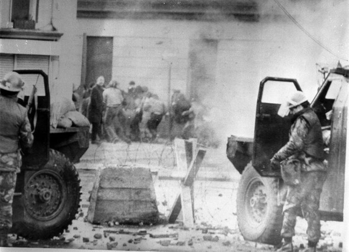 Soldats anglesos es protegeixen darrere dels seus cotxes després de disparar gasos contra els manifestants catòlics. Soldats anglesos es protegeixen darrere dels seus cotxes després de disparar gasos contra els manifestants catòlics.