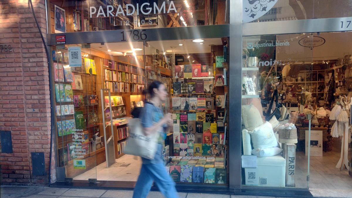Una mujer pasea junto a un librería en Buenos Aires.
