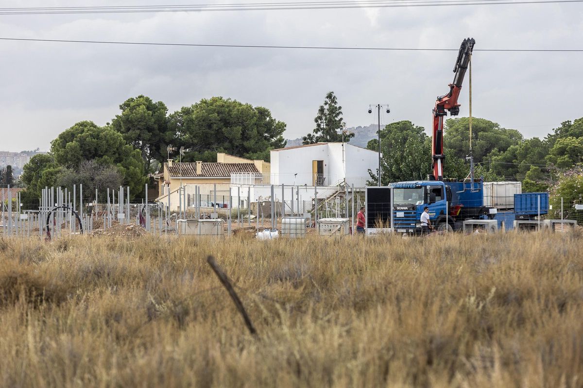 Trabajadores, en plena labor de instalación y, al fondo, varias casas, en una imagen de esta semana