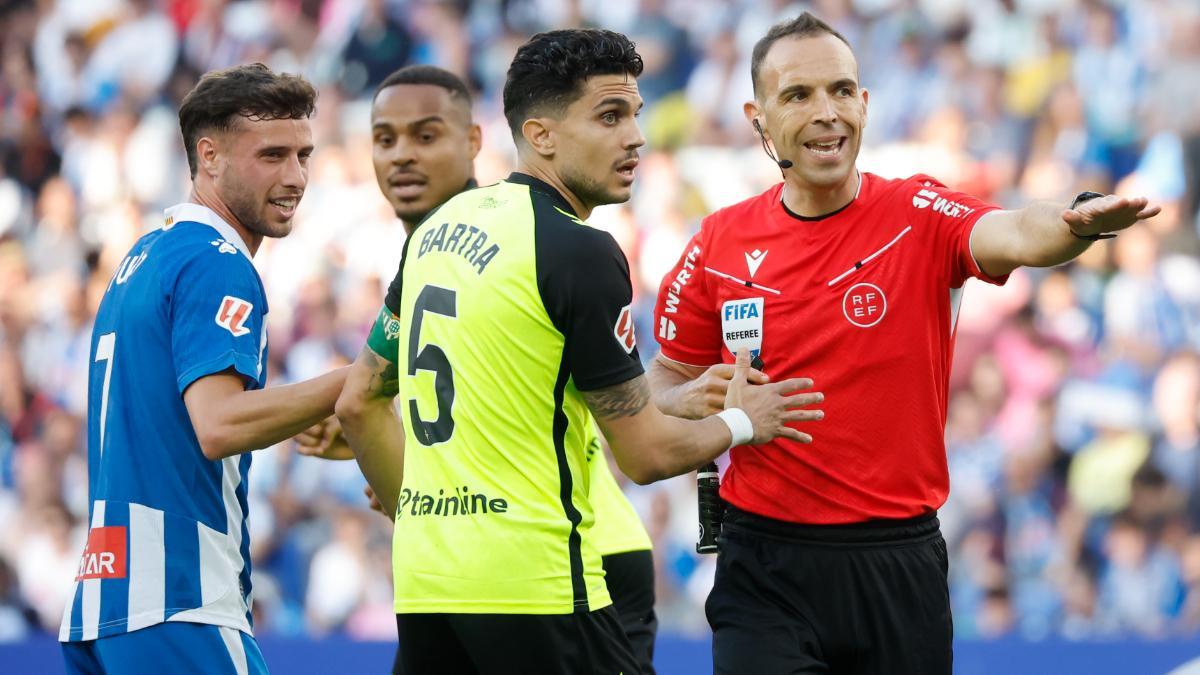 El árbitro del partido Guillermo Cuadra Fernández conversa con Bartra del Betis, durante el partido en el RCDE Stadium