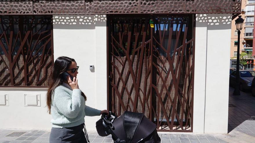 Una mujer pasa por delante de un apartamento turístico ubicado en un bajo comercial. | GERMÁN CABALLERO