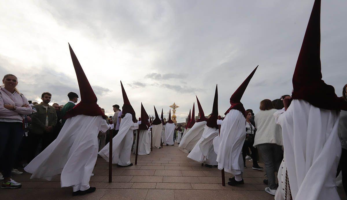 Nazarenos de la Vera Cruz procesionan en un día nublado.