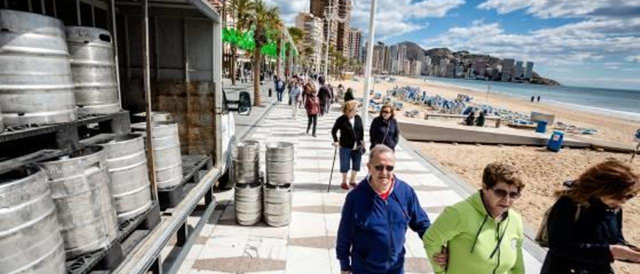 Unos turistas caminan junto a uno de los camiones aparcados en el paseo de Levante.