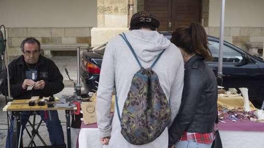 Una pareja observa las pulseras expuestas.