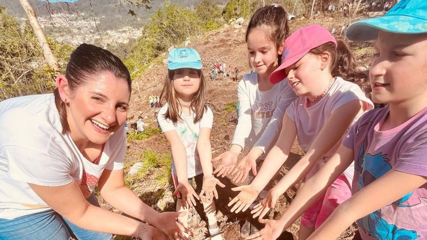 La alcaldesa de Moaña y niños muestran sus manos manchadas de tierra.  | // G.N.