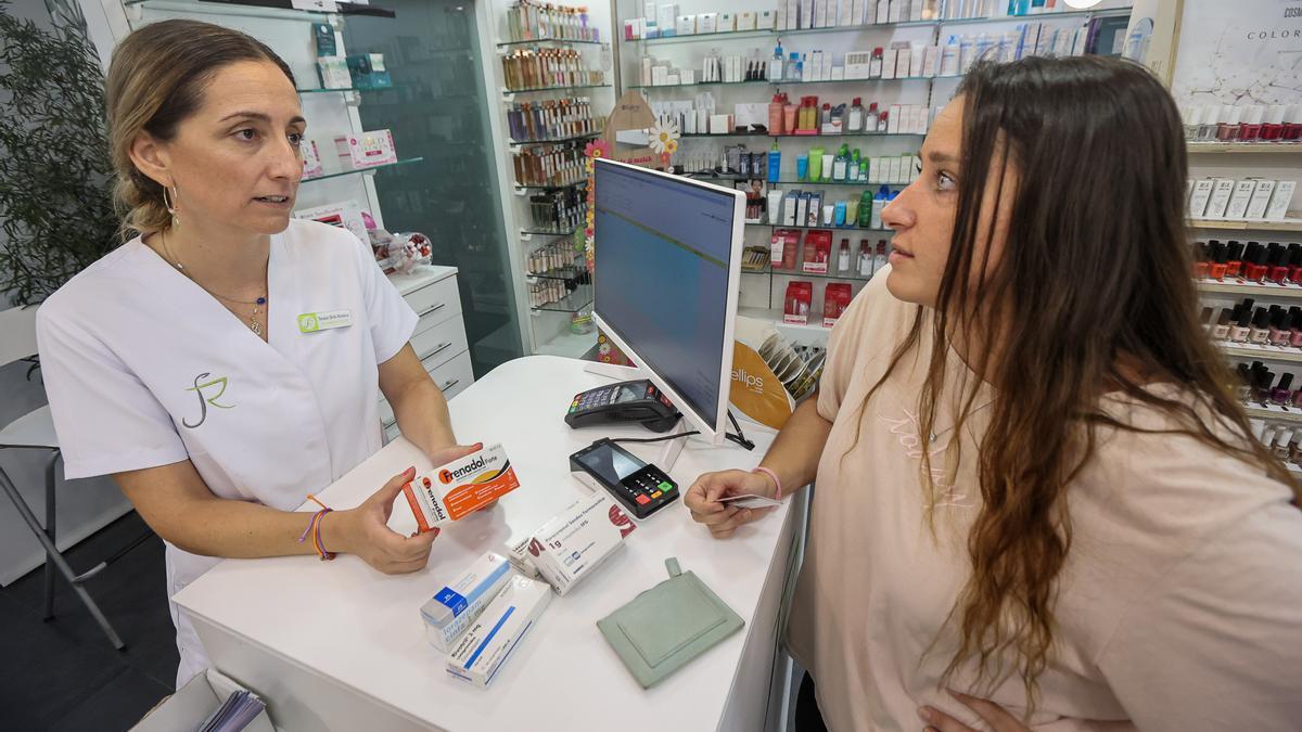 Una farmacéutica de Alicante atiende a una paciente, este viernes