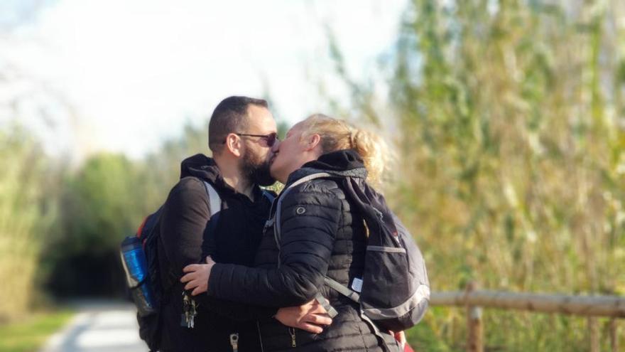 Juan y Sara se dan un beso junto a su mascota Pol.