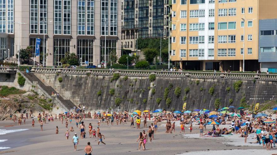Bañistas en la playa de Orzán durante la pleamar.