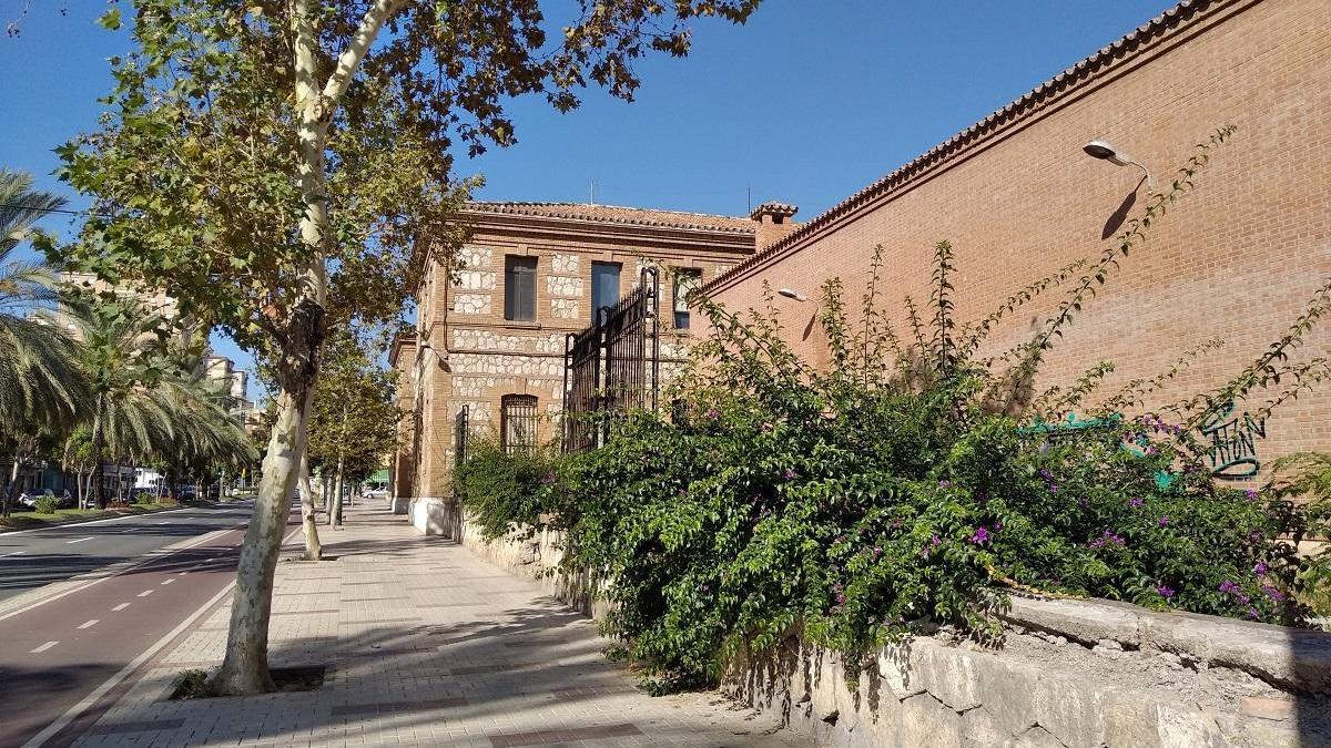 En la foto, el tramo sin verja de la antigua prisión provincial, en la Cruz del Humilladero, después de que el peso de dos enormes buganvillas terminaran inclinando la verja hasta romper la base de piedra, por falta de mantenimiento.