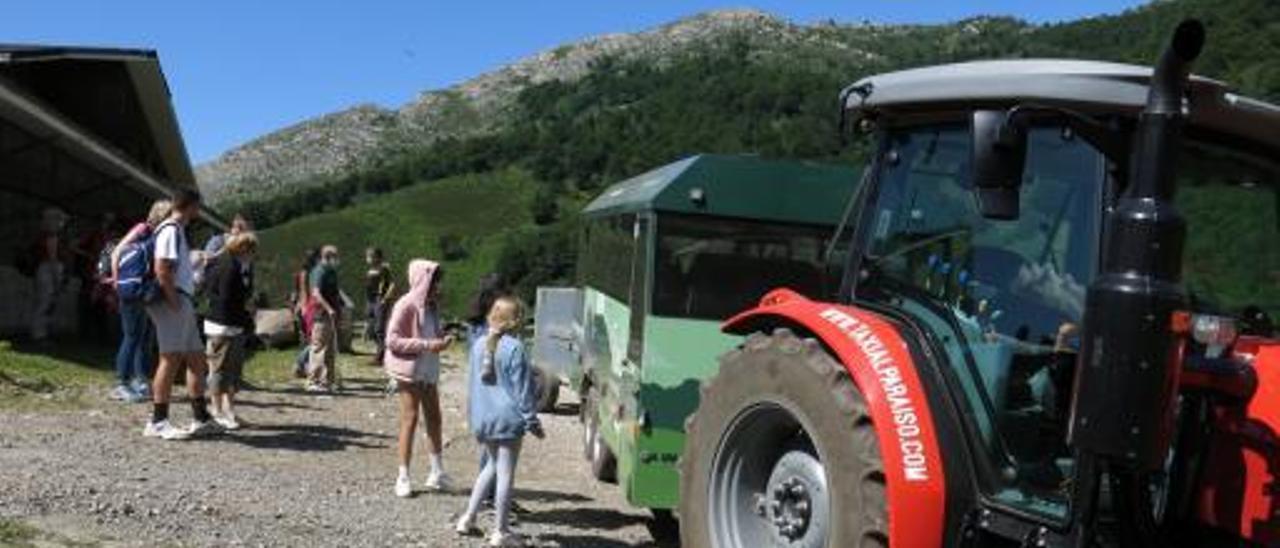 Un grupo de turistas junto al “tren turístico” que sube hasta el refugio de Brañagallones. | Fernando Rodríguez