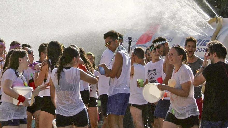 Los jóvenes llevándose el remojón de la plaza dels Hostals.