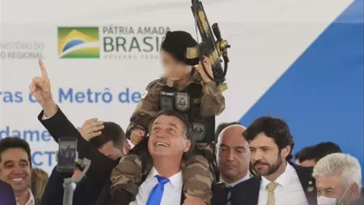 Jair Bolsonaro, con el niño vestido de militar y con una metralleta de juguete.