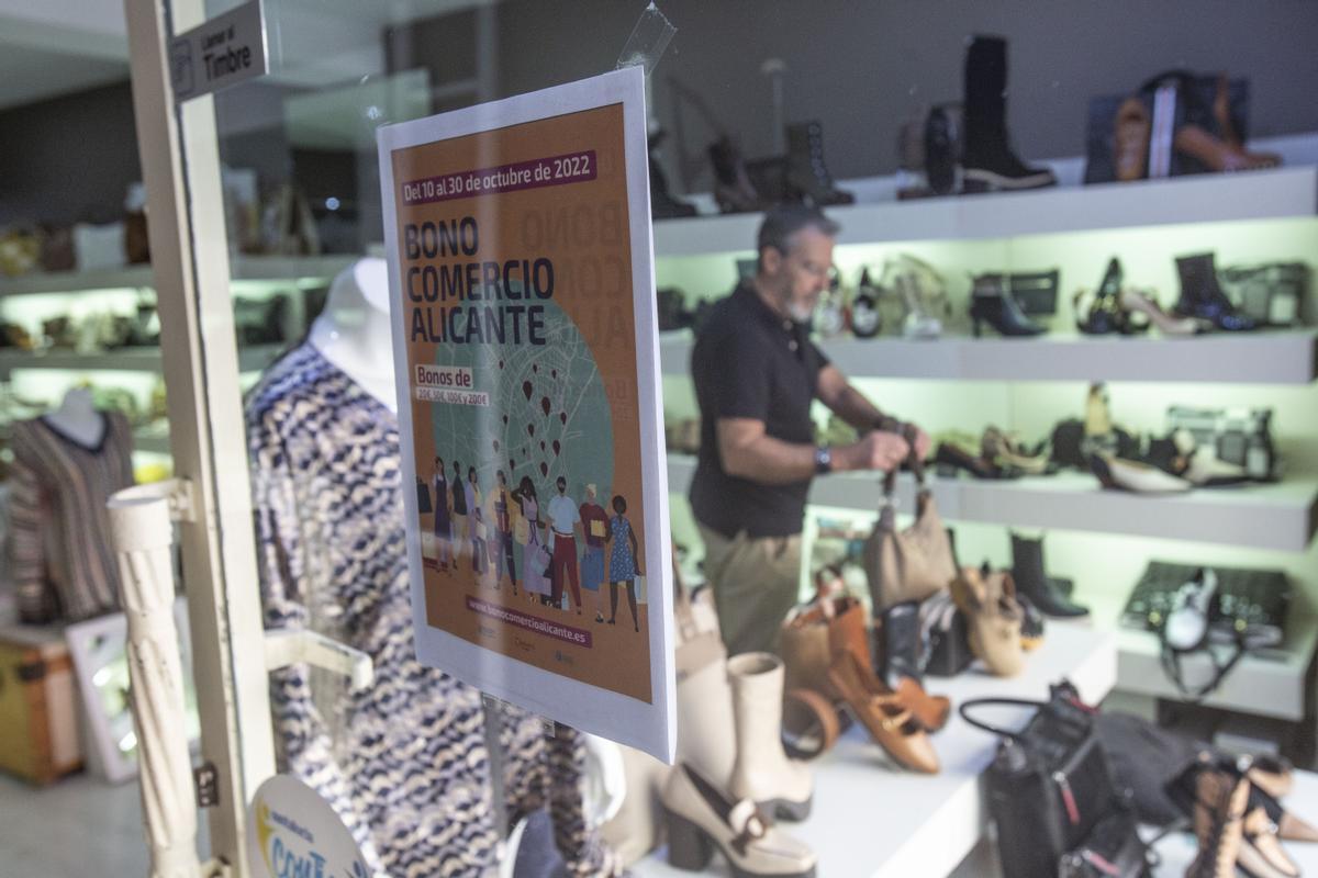 Una tienda de calzado, con el cartel del bono comercio de octubre en su escaparate.