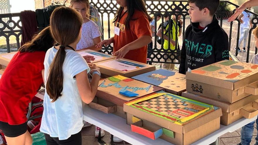 Varios niños con las maletas de cartón donde guardan los juegos tradicionales.