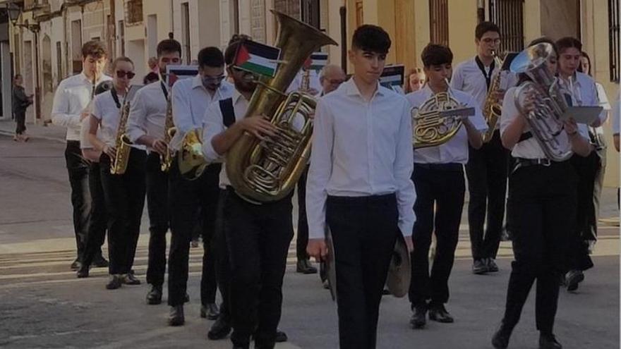La Banda de Rocafort desfila con una bandera Palestina durante el Corpus
