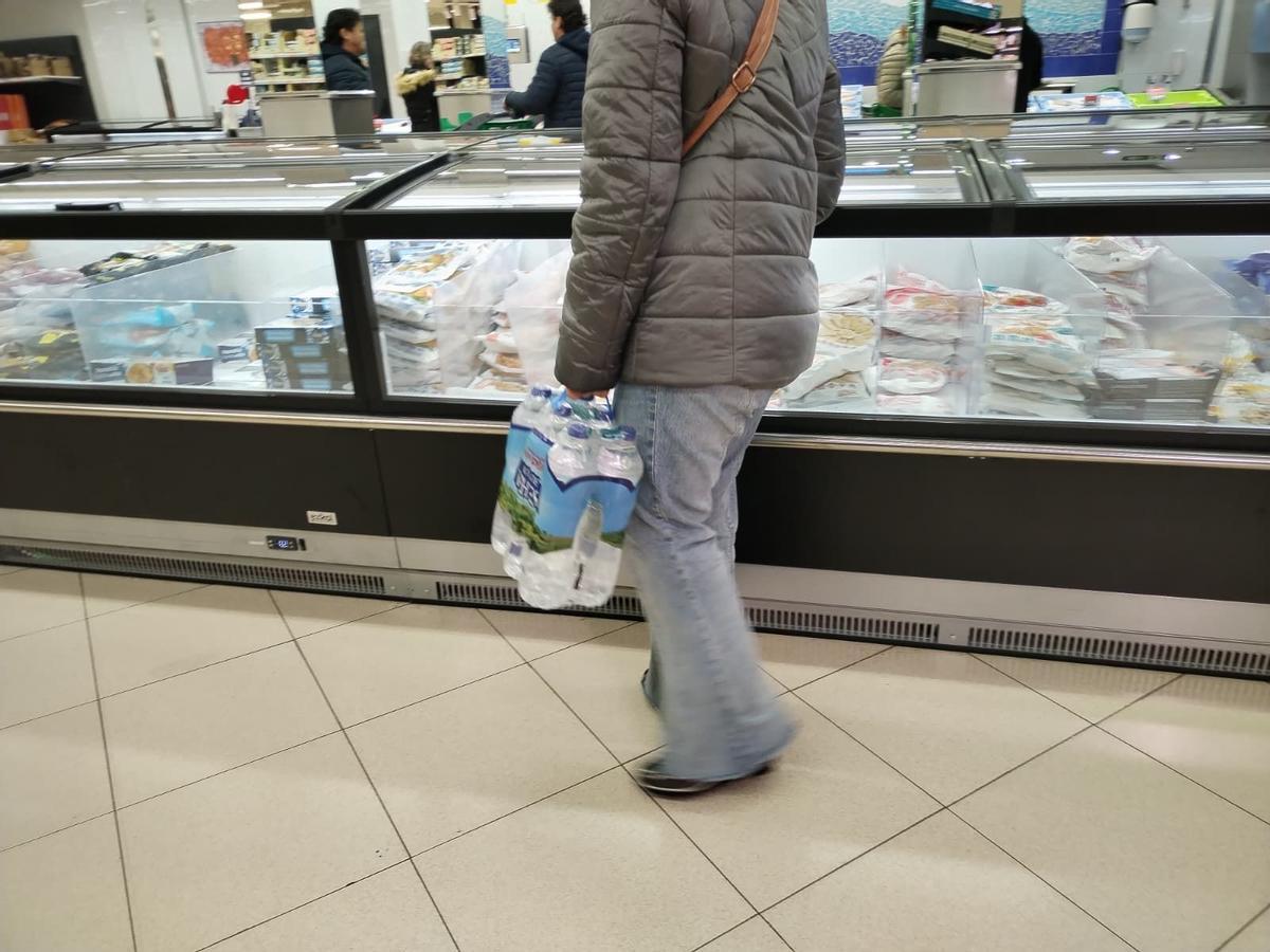 Una persona con botellas de agua, por la recomendación de no consumirla del grifo en Plasencia.