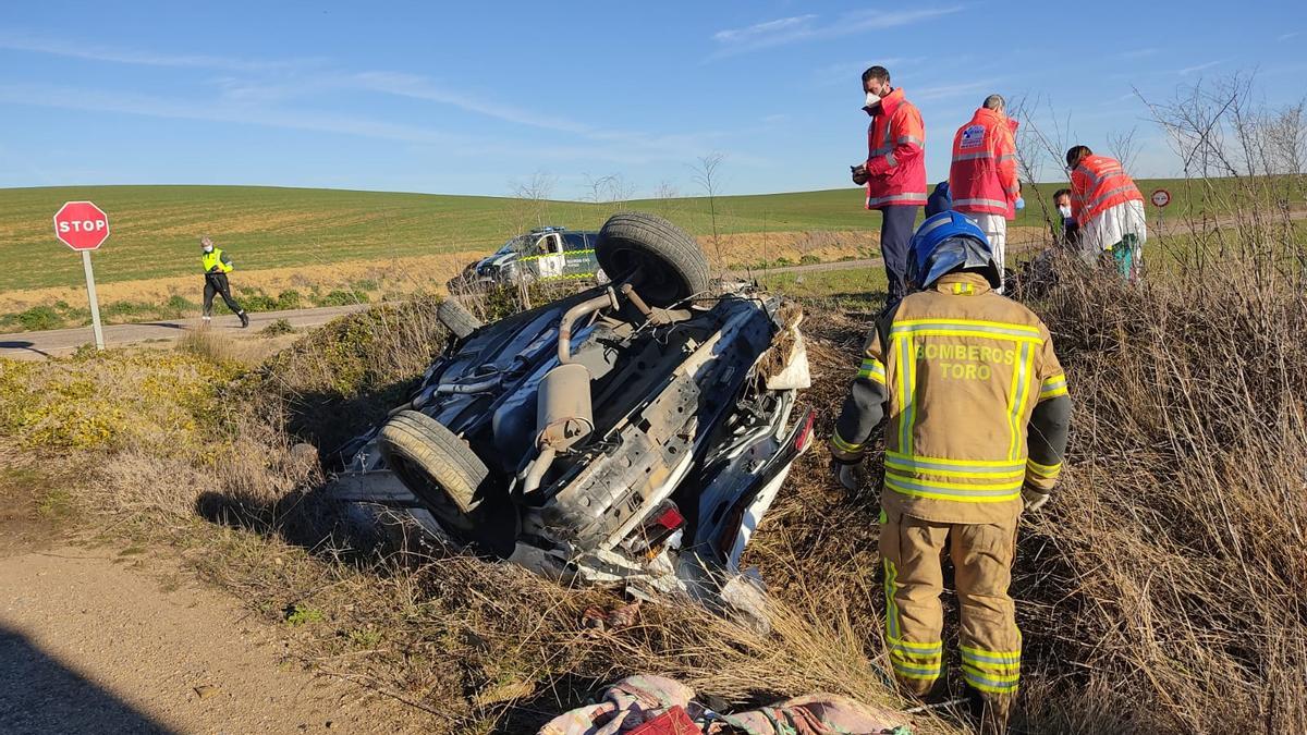 Bomberos y sanitarios atienden al conductor junto al coche siniestrado