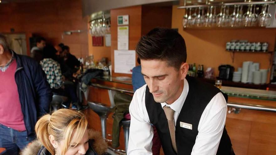 Un trabajador del hotel Silken sirve dos pinchos &quot;Nada de nada&quot; a dos clientes ayer a mediodía.