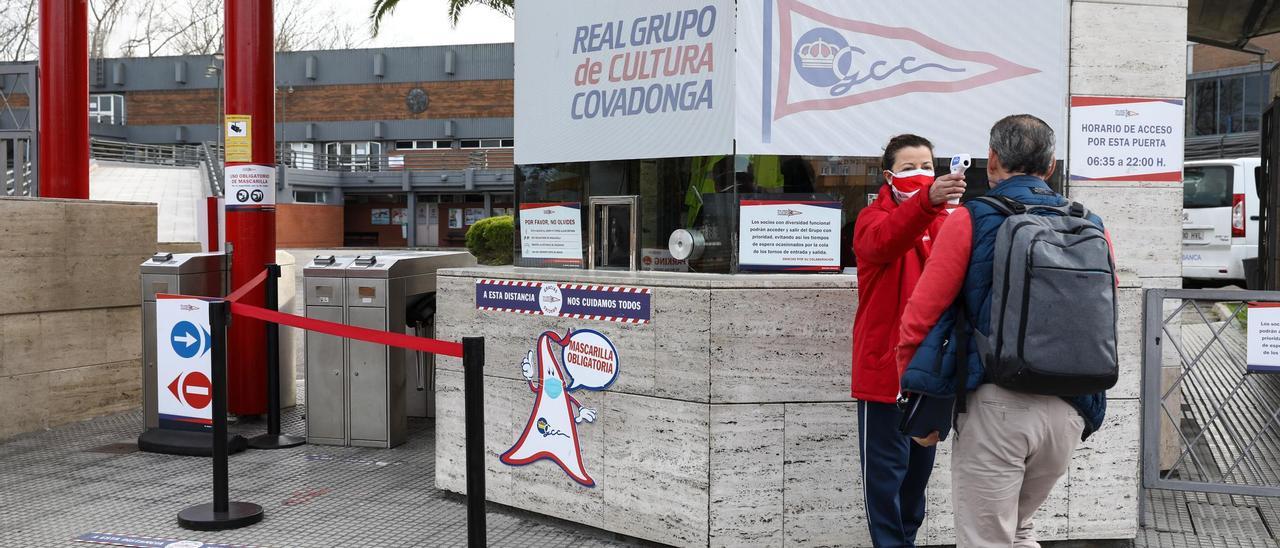 Una trabajadora del club revisa la temperatura a un socio a la entrada de la sede del Grupo en Las Mestas.