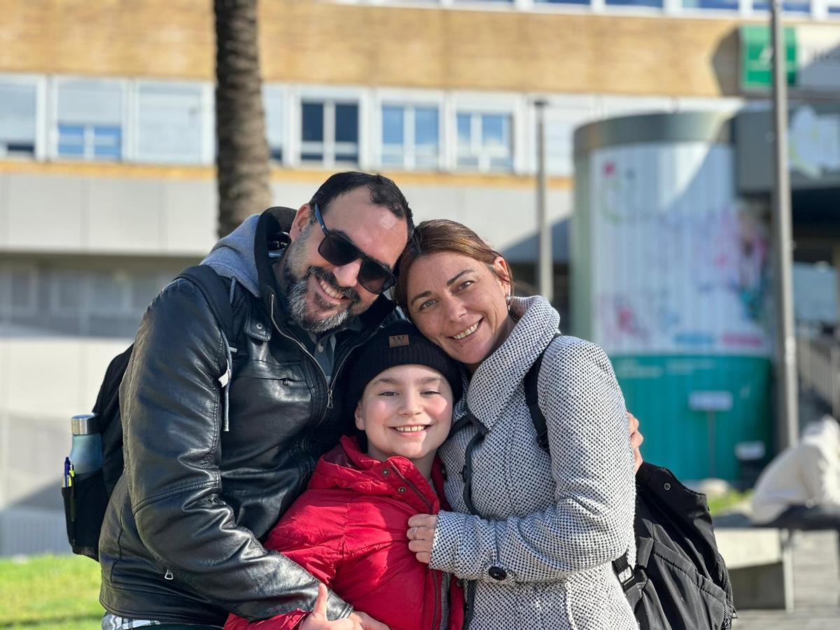 Lucas junto a sus padres en la entrada del Hospital de Día del Virgen del Rocío.